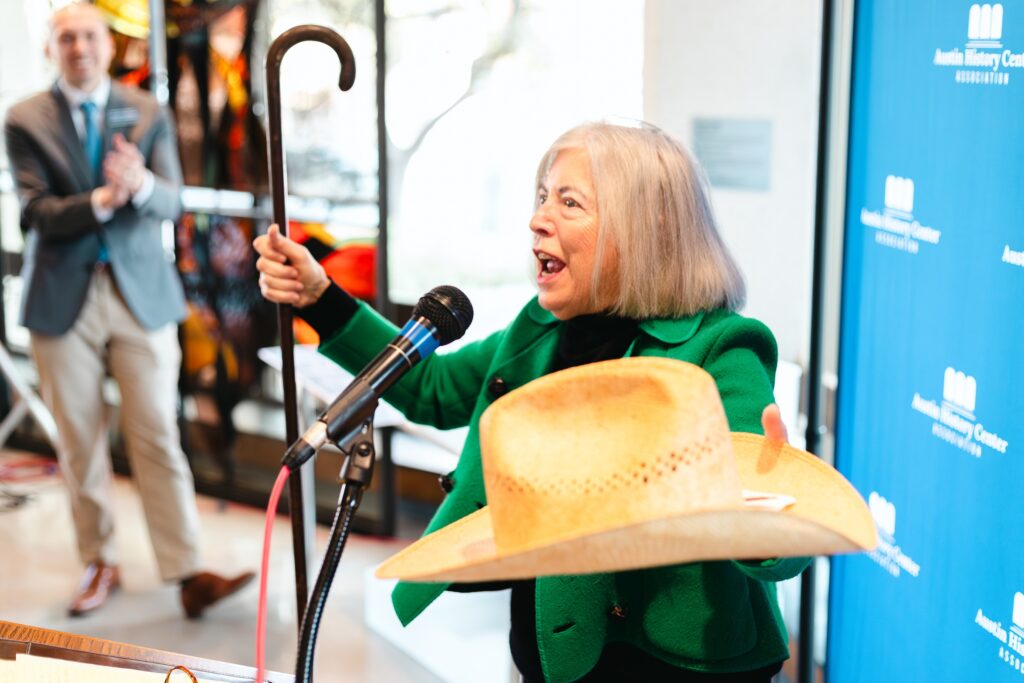 Judge Jan Patterson displays the hat and cane that belonged to John Henry Faulk, the namesake of the building housing the Austin History Center.