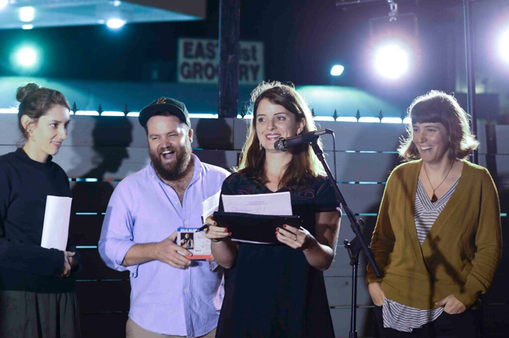 Adeena Reitberger (at microphone) speaks at Lit Crawl, an American Short Fiction event. Left to right, Rebecca Markovits, Nate Brown, Adeena, and Heather Hasselle.