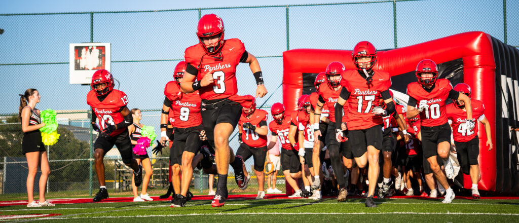 Senior Crawford Moffitt (QB, #3) leads the tunnel run-out at the start of a home game. Sophomore Carson Young (DB, #13), Senior Phoenix Smith (DB, #9), Senior Noah Nixon (CB, #17), Senior Garrett Gunnoe (WR, #10)