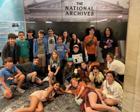 Visiting the National Archives Museum in Washington, D.C. (Standing Back Row, L to R): Alex C., Riji C., Malcolm R., Elijah A., Rishaan M., Jeremy U., Jia S., Eveline N., Sam M., Carina A. (Kneeling/Sitting Middle Row, L to R): Sebastian C., Asher B., Corie H., Nathan U. (blue hat), Brydon D. (holding the "Claim the World for Paragon" Flag), Sonia A. (giving the peace sign), Tenley G., Ella G. (Front Row Lying Down, L to R): Reena D., Violet N., Olivia N. (far right, sitting)