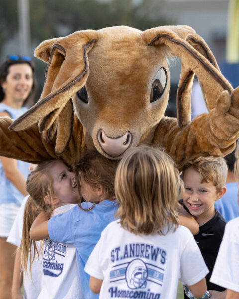 Mascot Scottie embracing students at the Homecoming Picnic