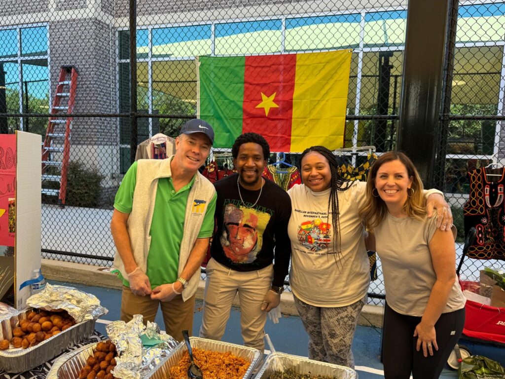 The Cameroon booth manned by Head of School Scott Hibbard and Magellan parents Kemar Hinds, Alexandria Robertson, and Becky Thompson