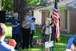 Scouts lead Grand Marshal Mayor Kirk Watson, Sheriff Sally Hernandez, Councilman Marc Duchen, and the crowd in the Pledge of Allegiance