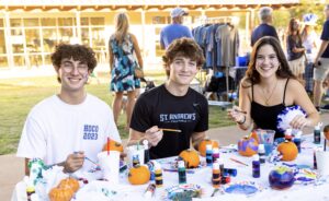 Bennett Julian, James Reilly, and Giulia Faini painting pumpkins at the Homecoming Picnic