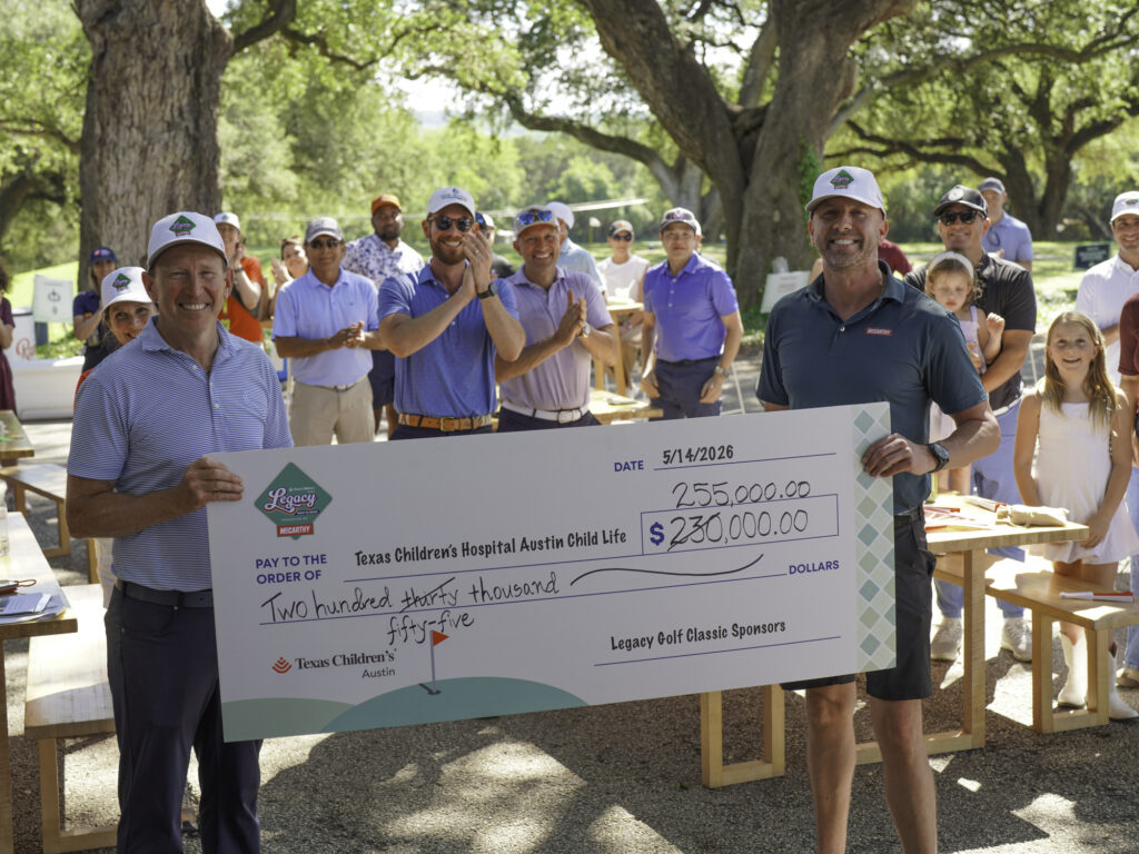 Dr. Jeffrey Shilt and Jeff Wood hold up the check for $255,000