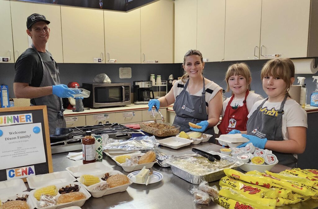 Wes and Kara Dixon with their two children — volunteering together at the Ronald McDonald House