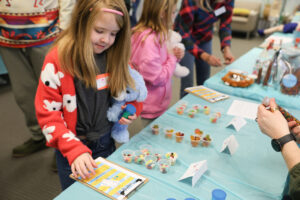 A WW child attending a Teddy Bear Clinic; an interactive “medical play” event using stuffed animals to receive care at a "mock hospital".