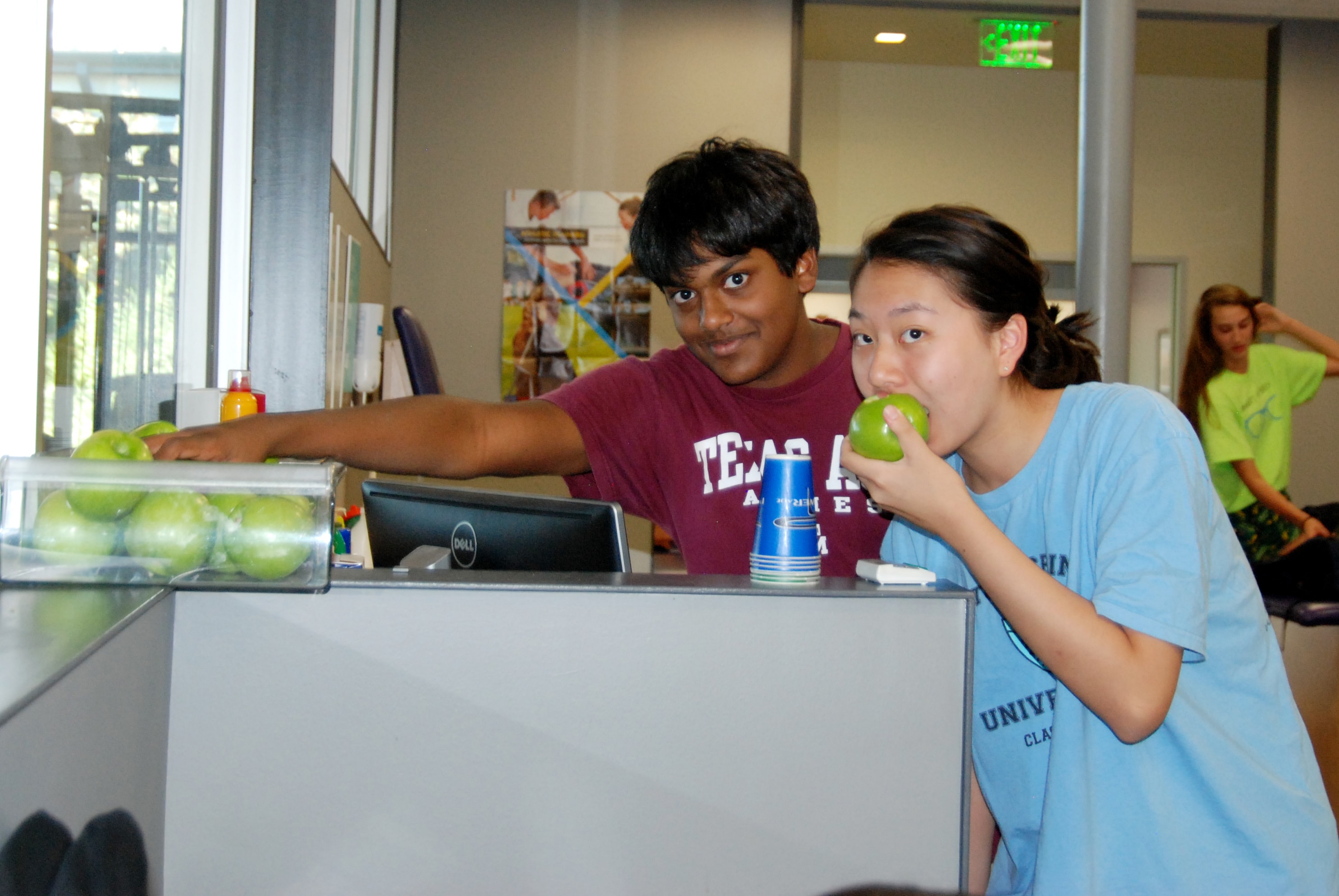  Student helper Kathy Oh and Noah George have juicy, nutritious apples as a snack in the athletic training room.